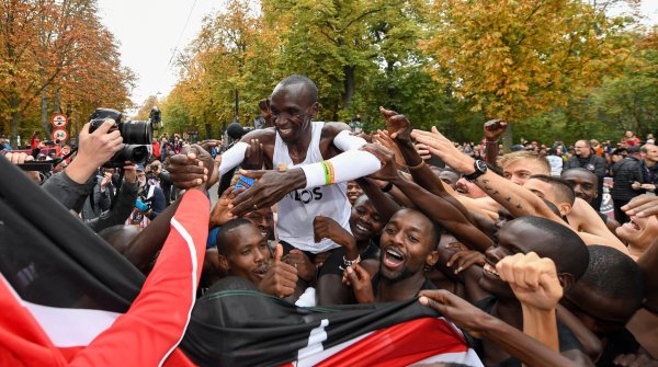 Behind the finish line, Eliud Kipchoge celebrates with his team.